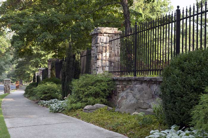 Maintenance yard along fence, shaping shrubs, trimming trees