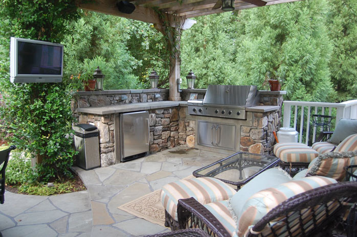 Outdoor kitchen with sitting area and stone patio