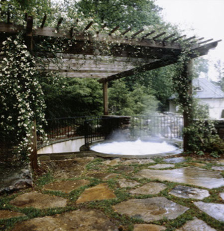 Pergola over spa with flowers and patio