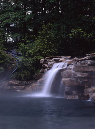 Water feature waterfall into pool over rocks